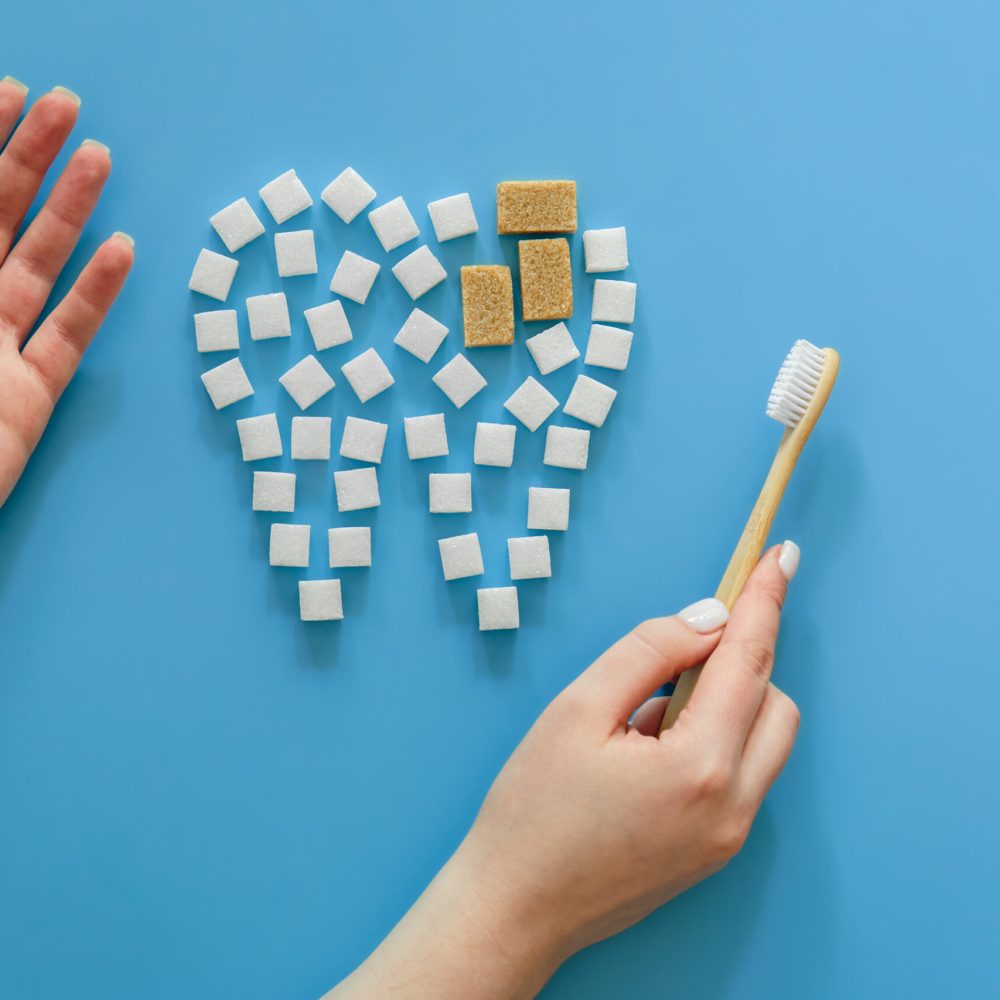 flat-lay-tooth-made-of-sugar-on-a-blue-background-2023-11-27-05-23-55-utc-scaled.jpg